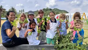 Children participating in gardening activities, learning and collaborating in nature.