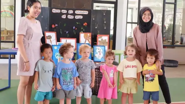 a group of kids standing with their two teachers