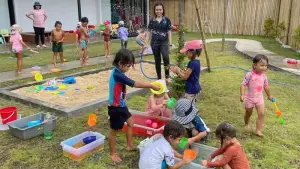 Tossing and bursting them while enjoying a playful outdoor activity.