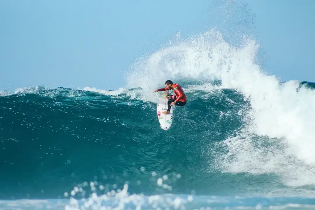 A surfer riding a wave on a sunny day.