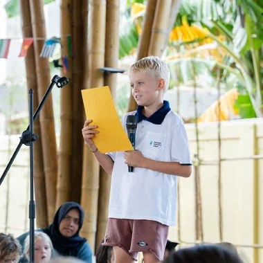 Individual delivering a speech in front of an audience, showcasing public speaking skills.